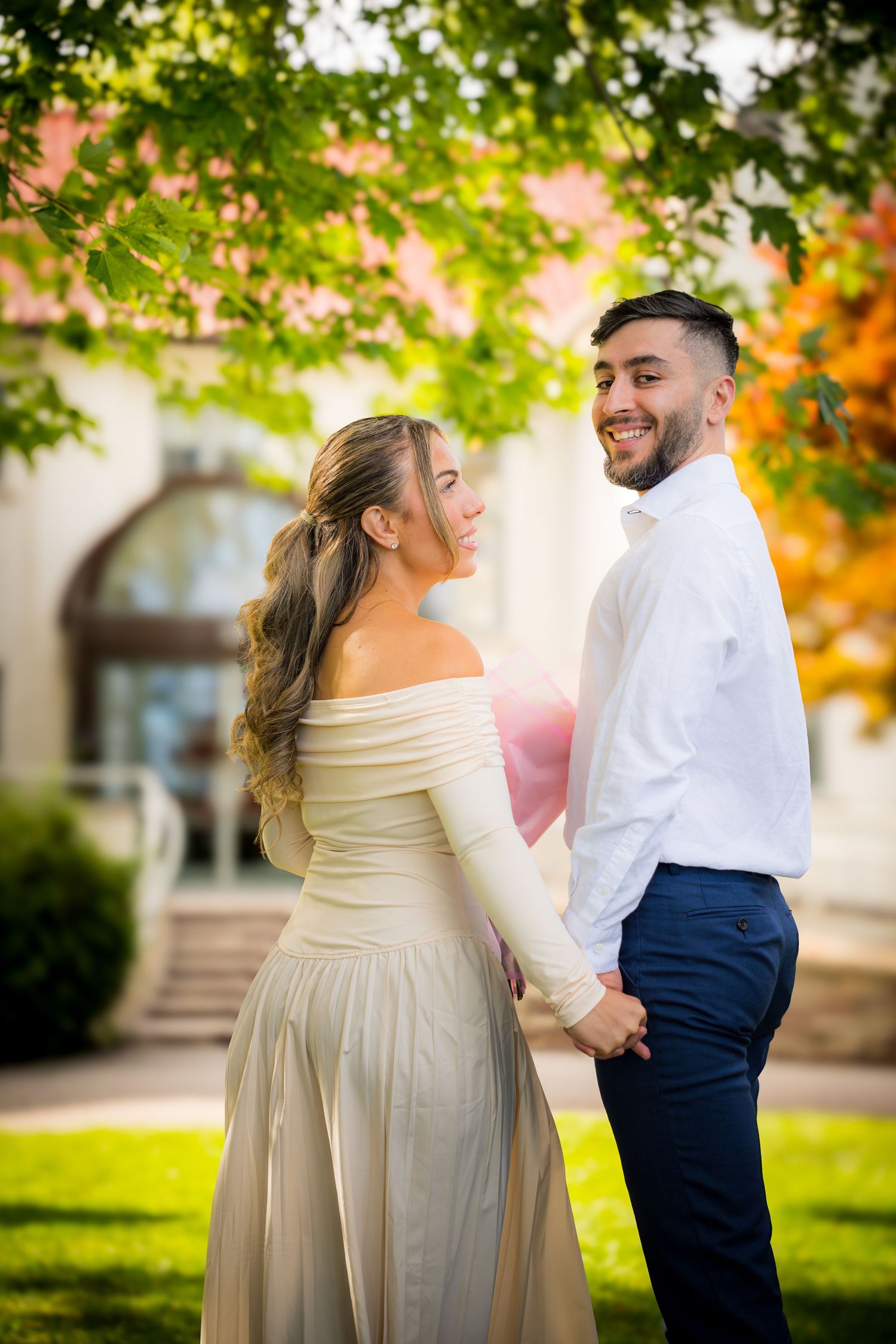 A romantic outdoor photo session captures a couple in formal attire against autumn foliage.