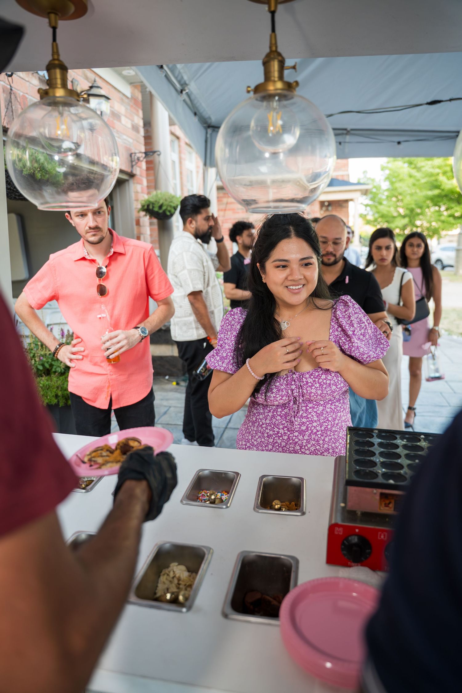 Guests enjoying treats at an outdoor dessert cart event.