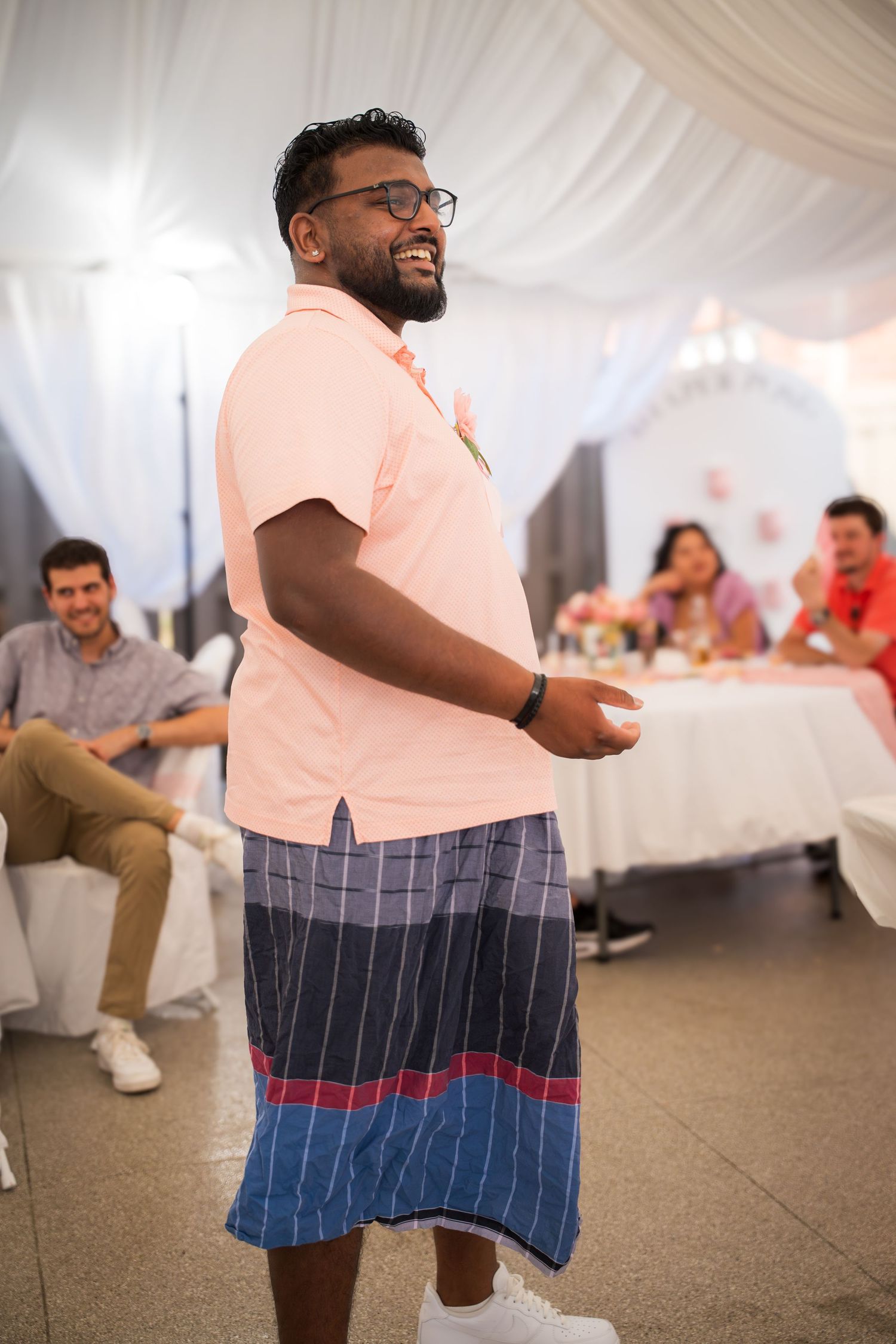 Guest in a peach shirt and striped shorts enjoying themselves on the dance floor.