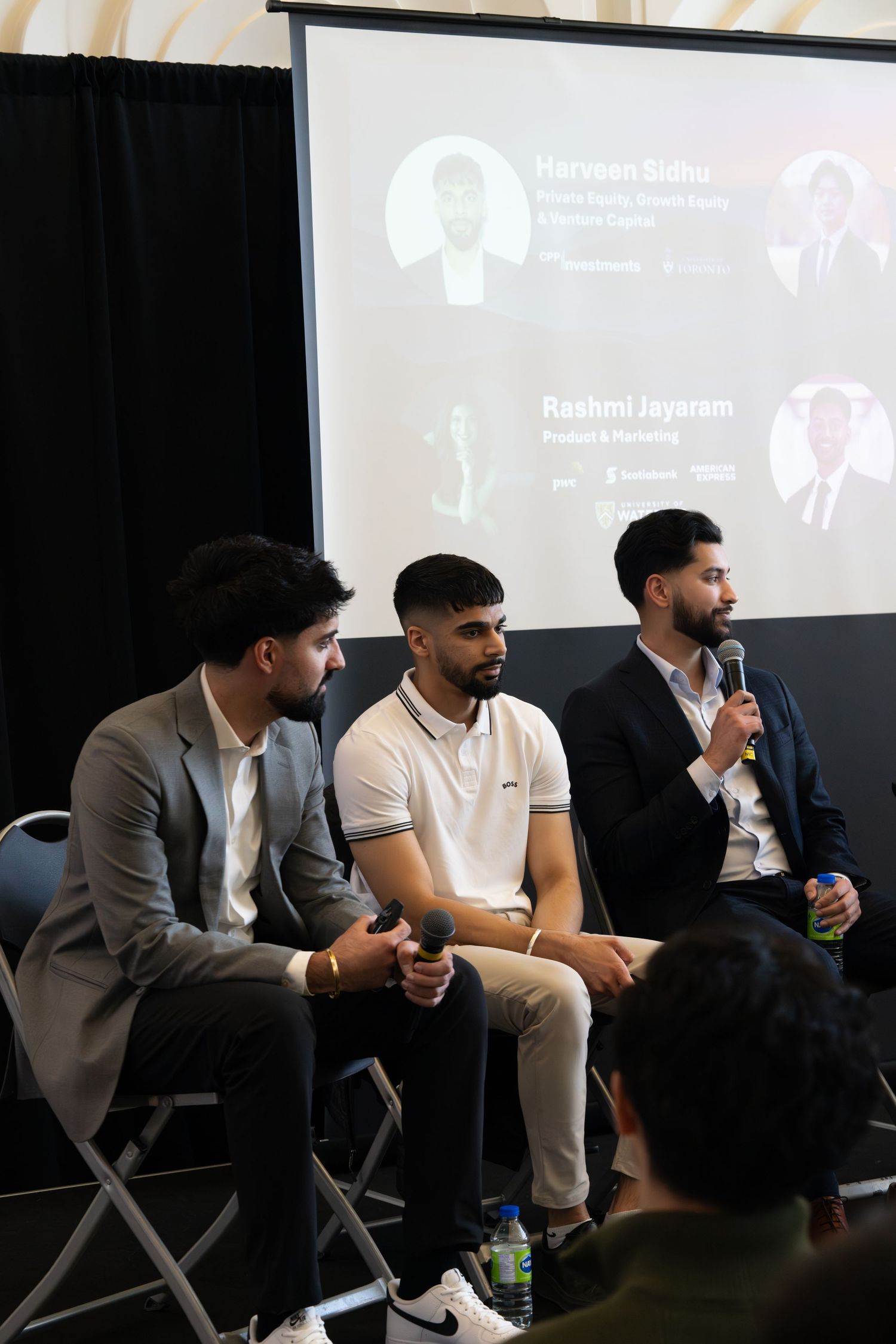 Wide shot of panel discussion showing multiple speakers engaged in conversation on stage.