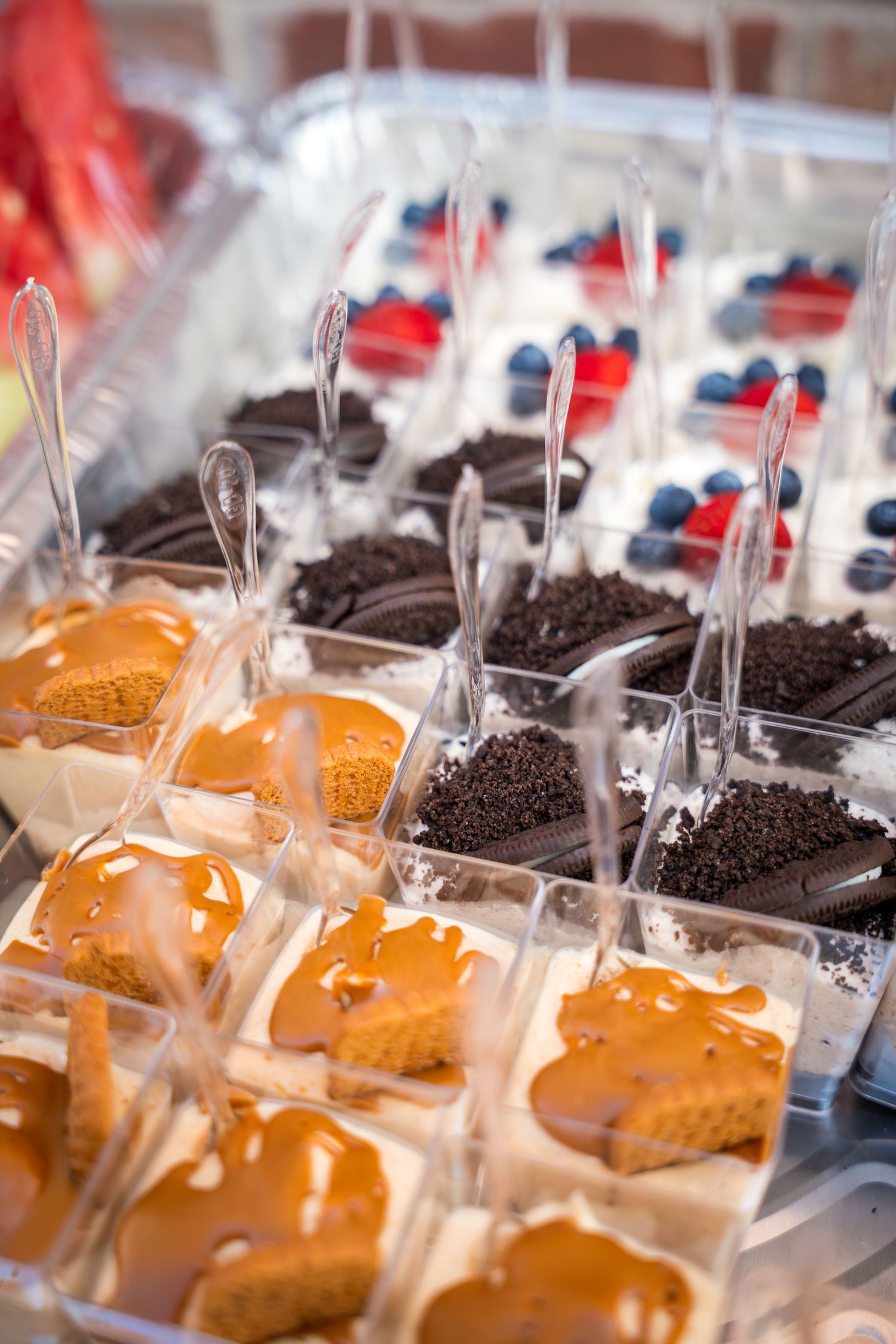 Rows of individually wrapped chocolate and caramel desserts displayed in clear plastic containers.