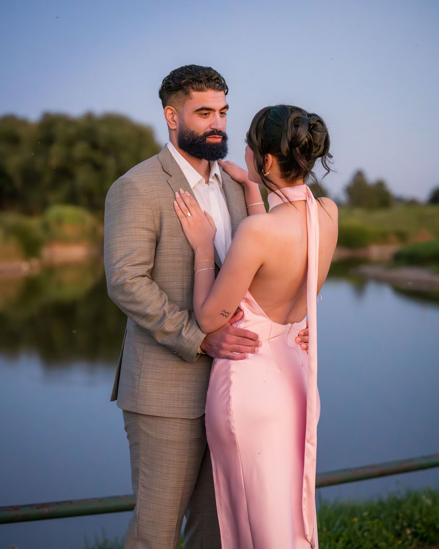 A couple shares an intimate moment during their lakeside photoshoot at sunset.
