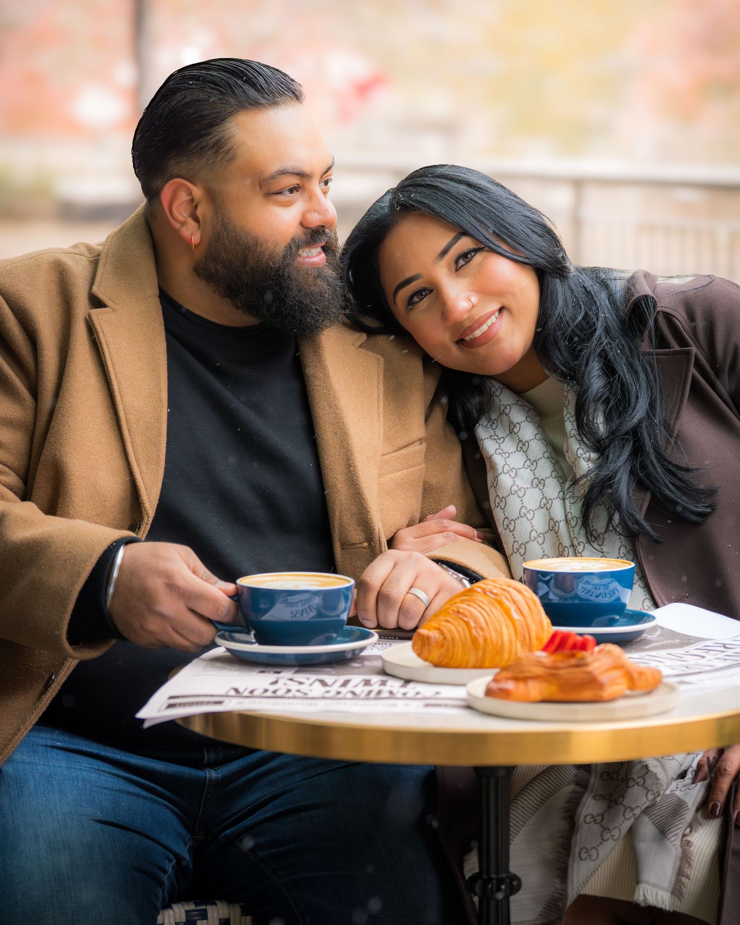 Romantic coffee date with croissants and lattes on a newspaper spread.