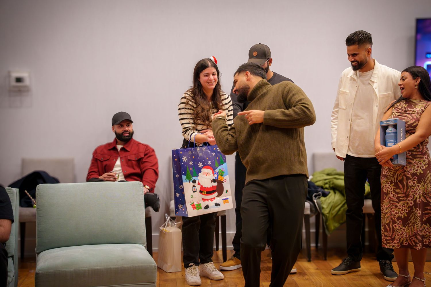 People gathered around during a gift exchange or party game in a modern living space.