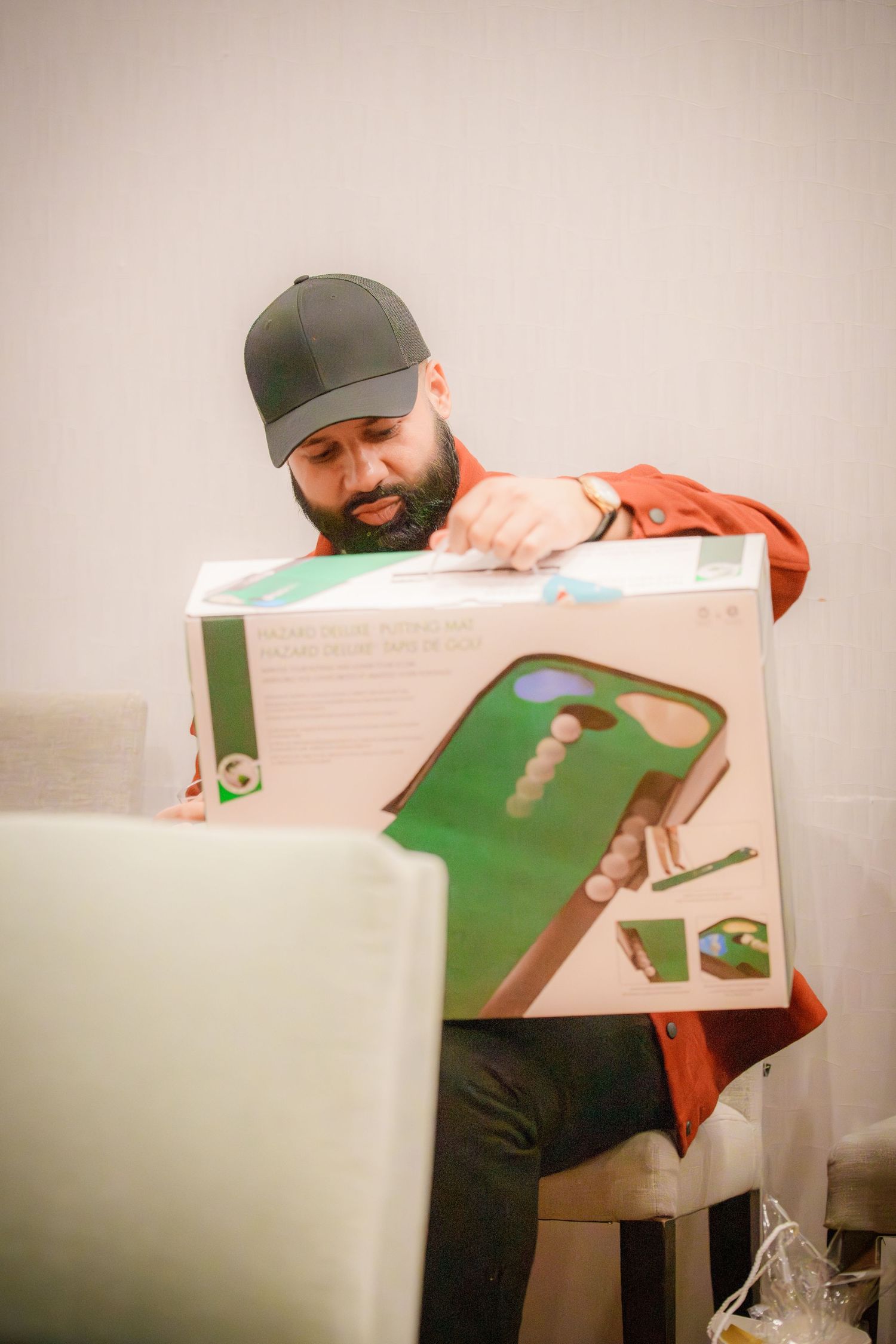 Person in a baseball cap examining a large white and green display board.