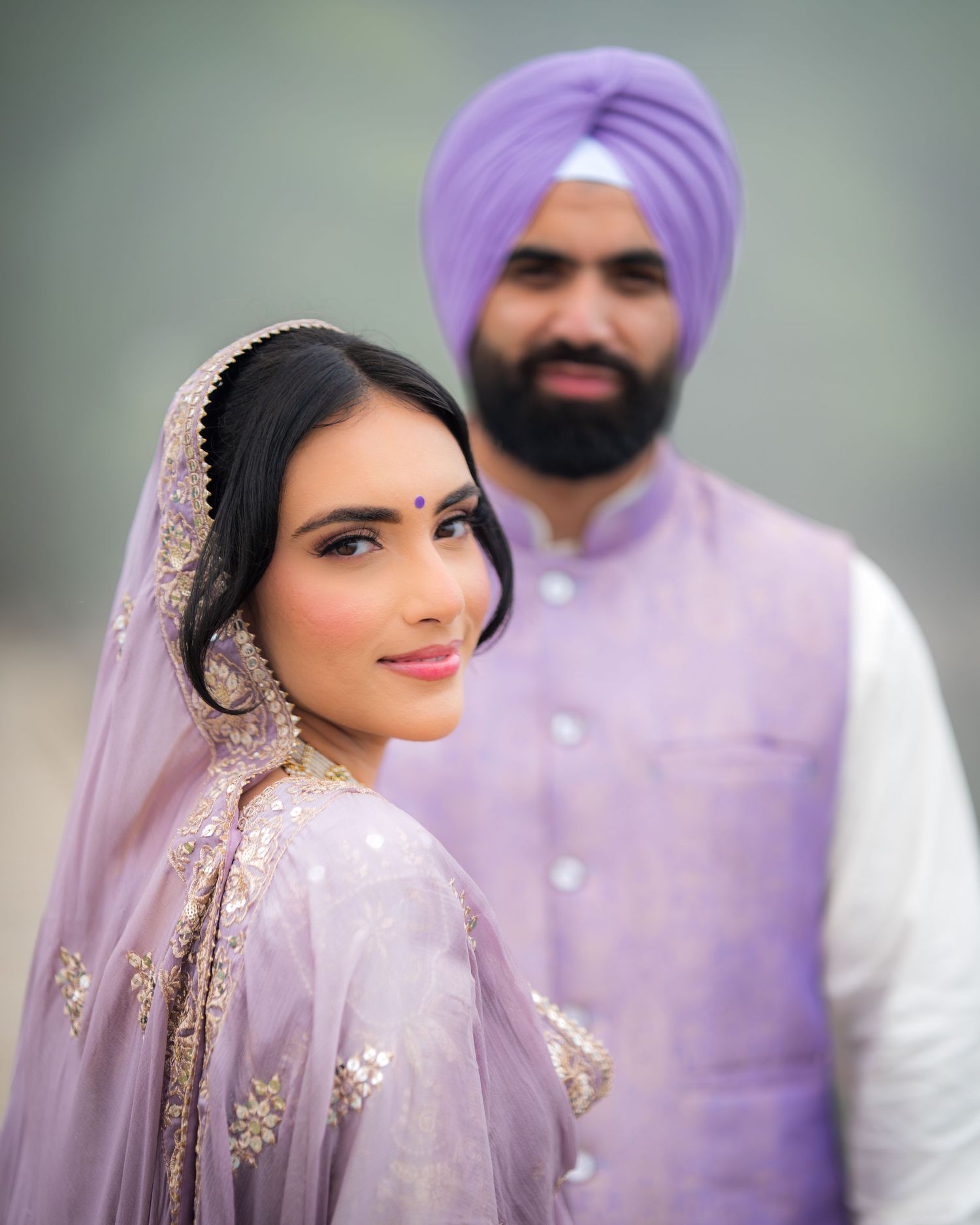 Artistic wedding portrait featuring soft purple tones and traditional Indian bridal details.