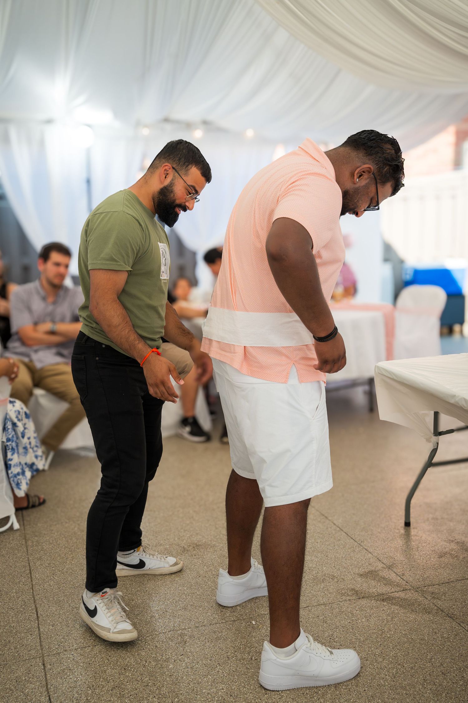 Event attendees participating in an interactive game or activity in a decorated tent venue.