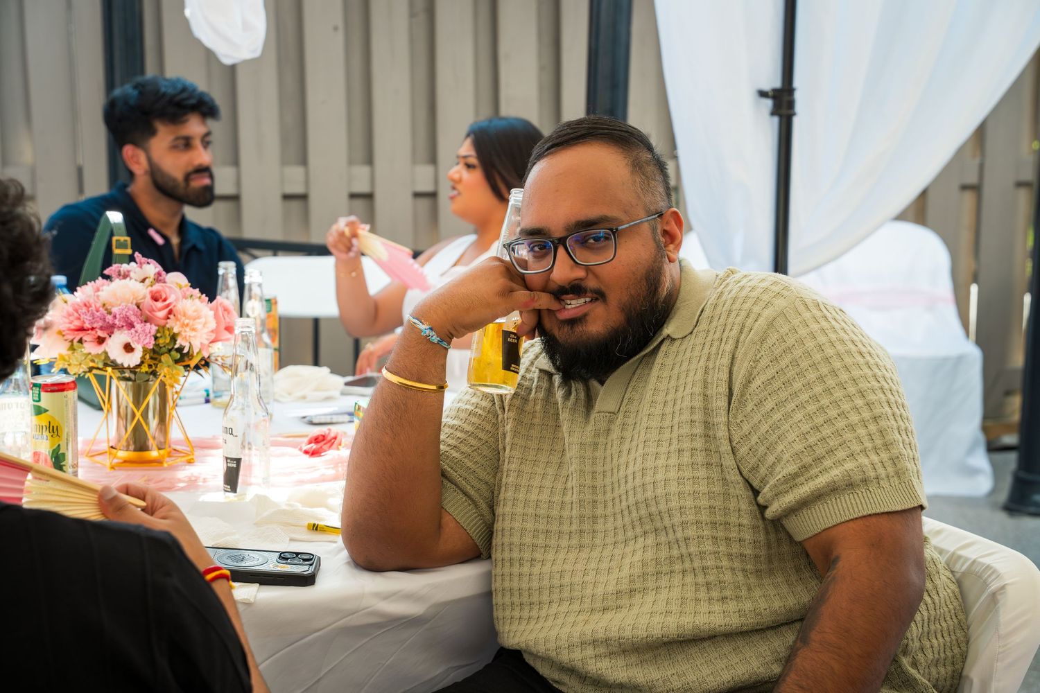 Guests seated at a celebration table with drinks and decorations.