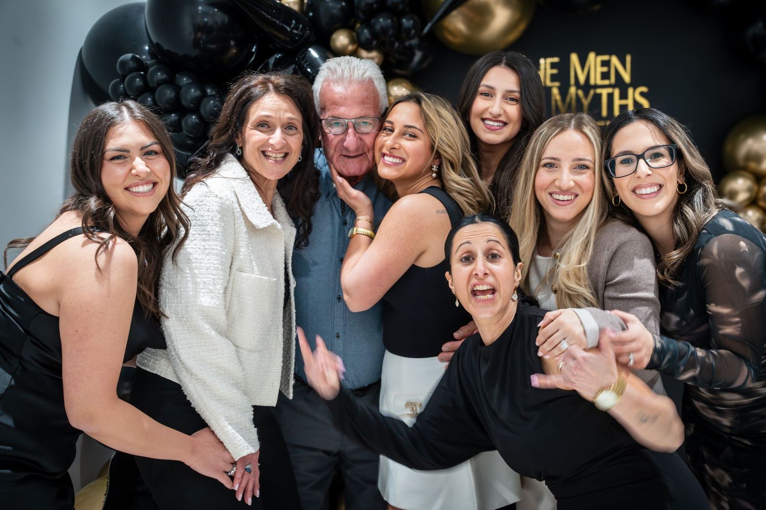 Festive party scene with guests celebrating against luxurious balloon decorations.