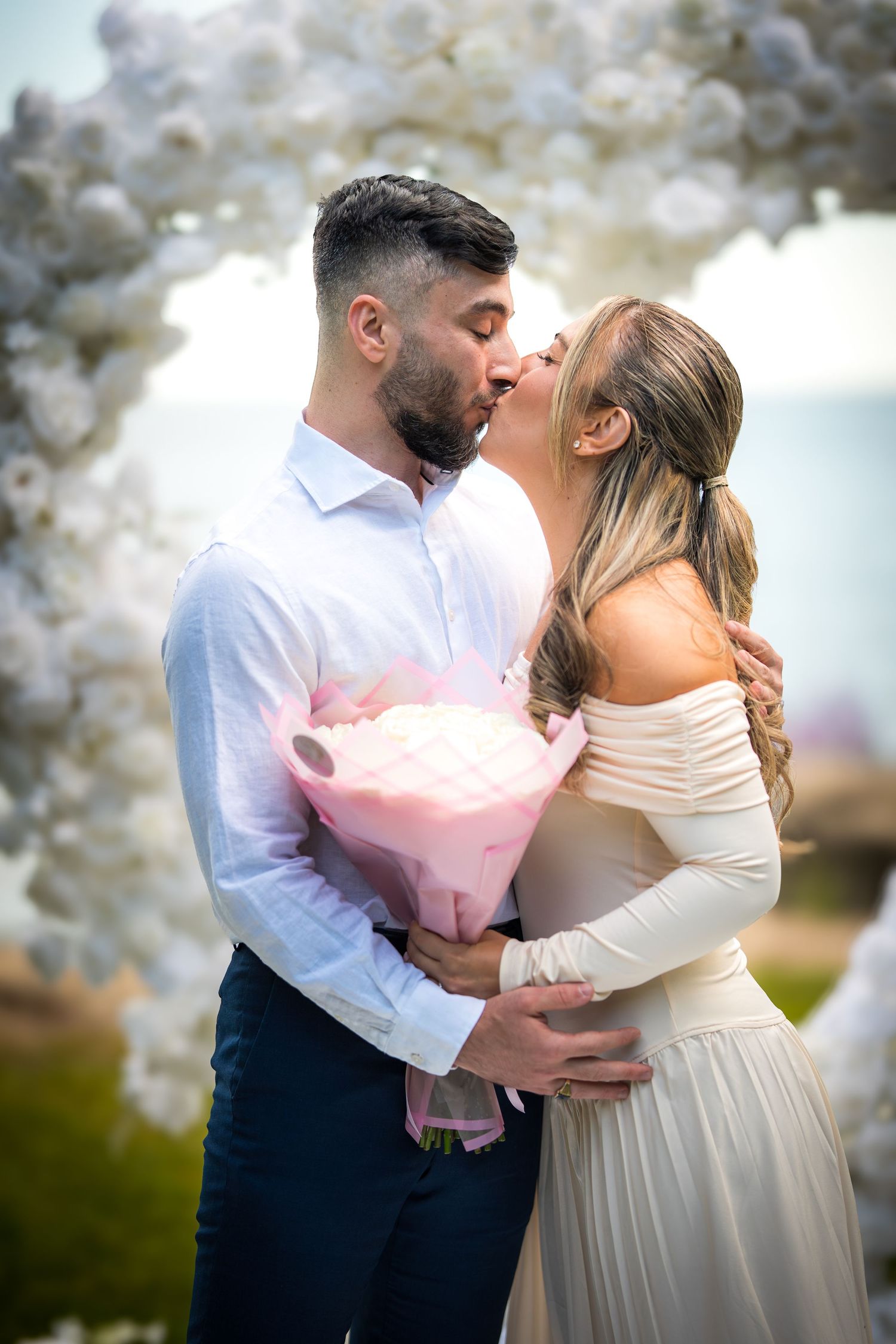 Romantic wedding dance with white balloon arch and soft lighting.