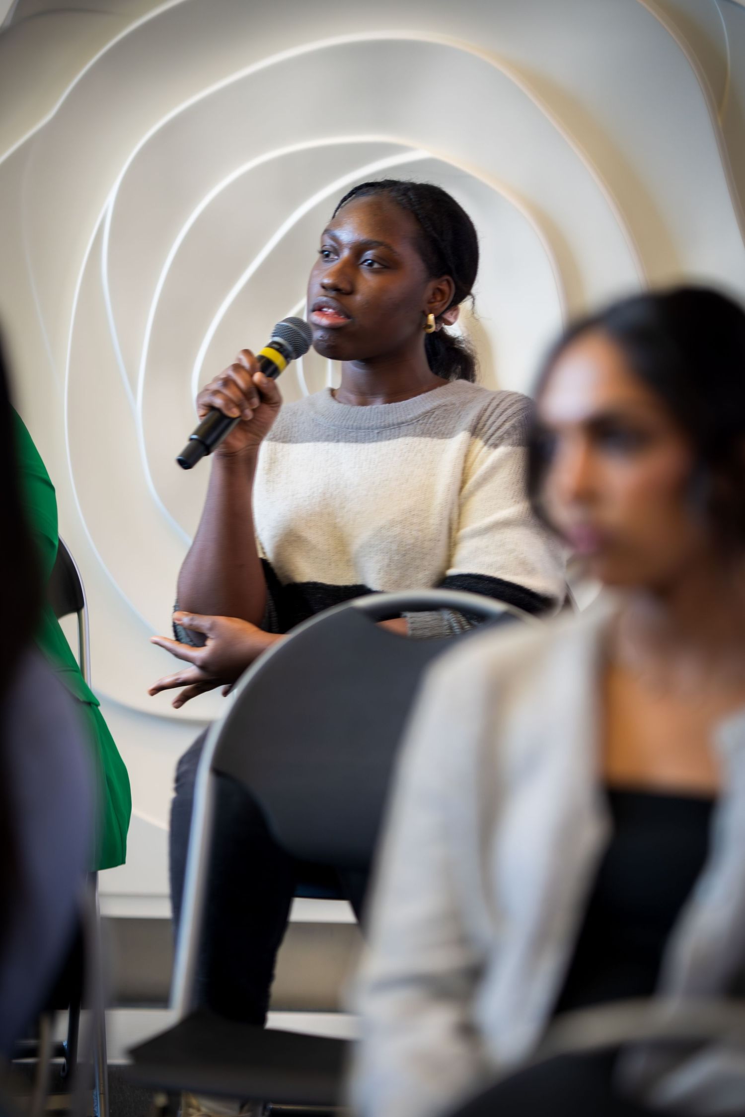 Speakers participate in a moderated panel discussion in a modern conference setting.