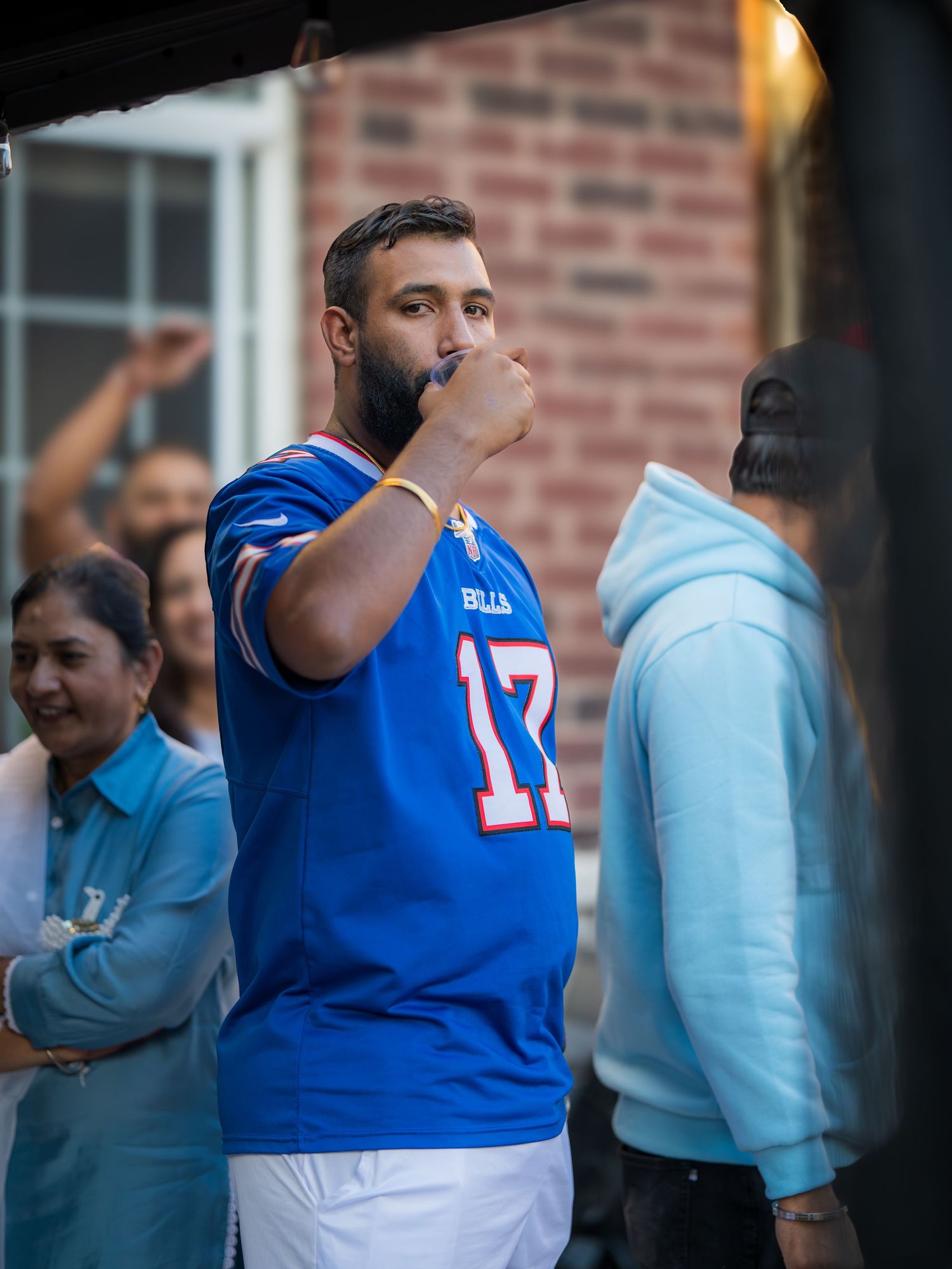 Man in Buffalo Bills jersey number 17 at an outdoor gender reveal celebration.