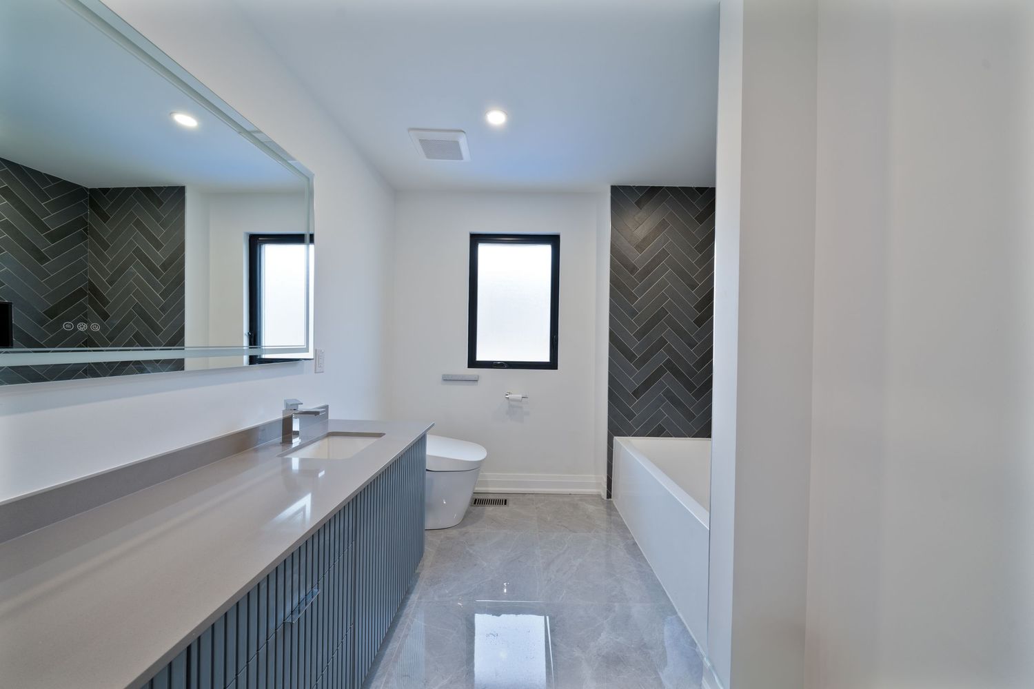 Contemporary hallway with white walls, black window frames, and herringbone pattern feature wall in dark tones.