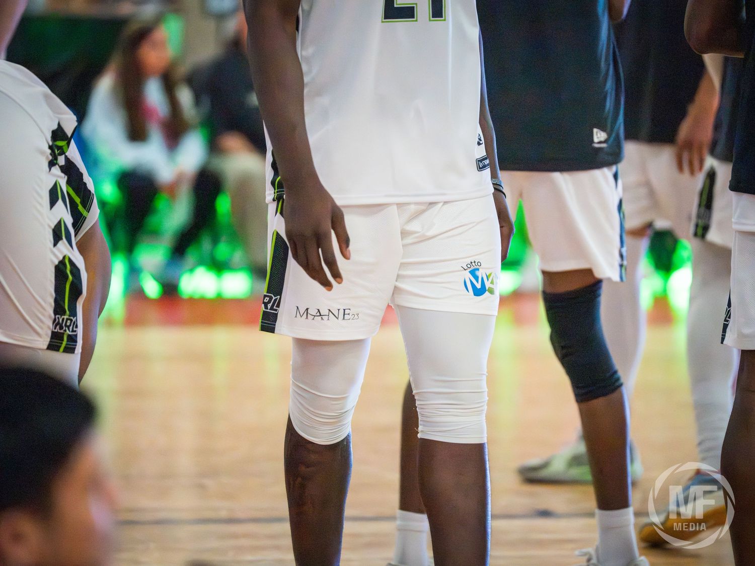 Niagara River Lions basketball player wearing white uniform with knee sleeve during a game.
