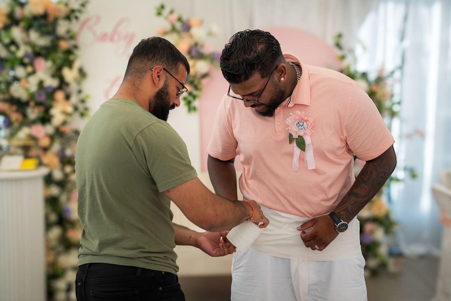 Guests enjoying an interactive game at a wedding reception under white tent decor.