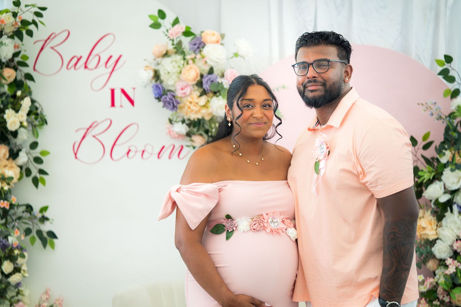 Baby shower event space decorated in pink with floral accents and white draping.