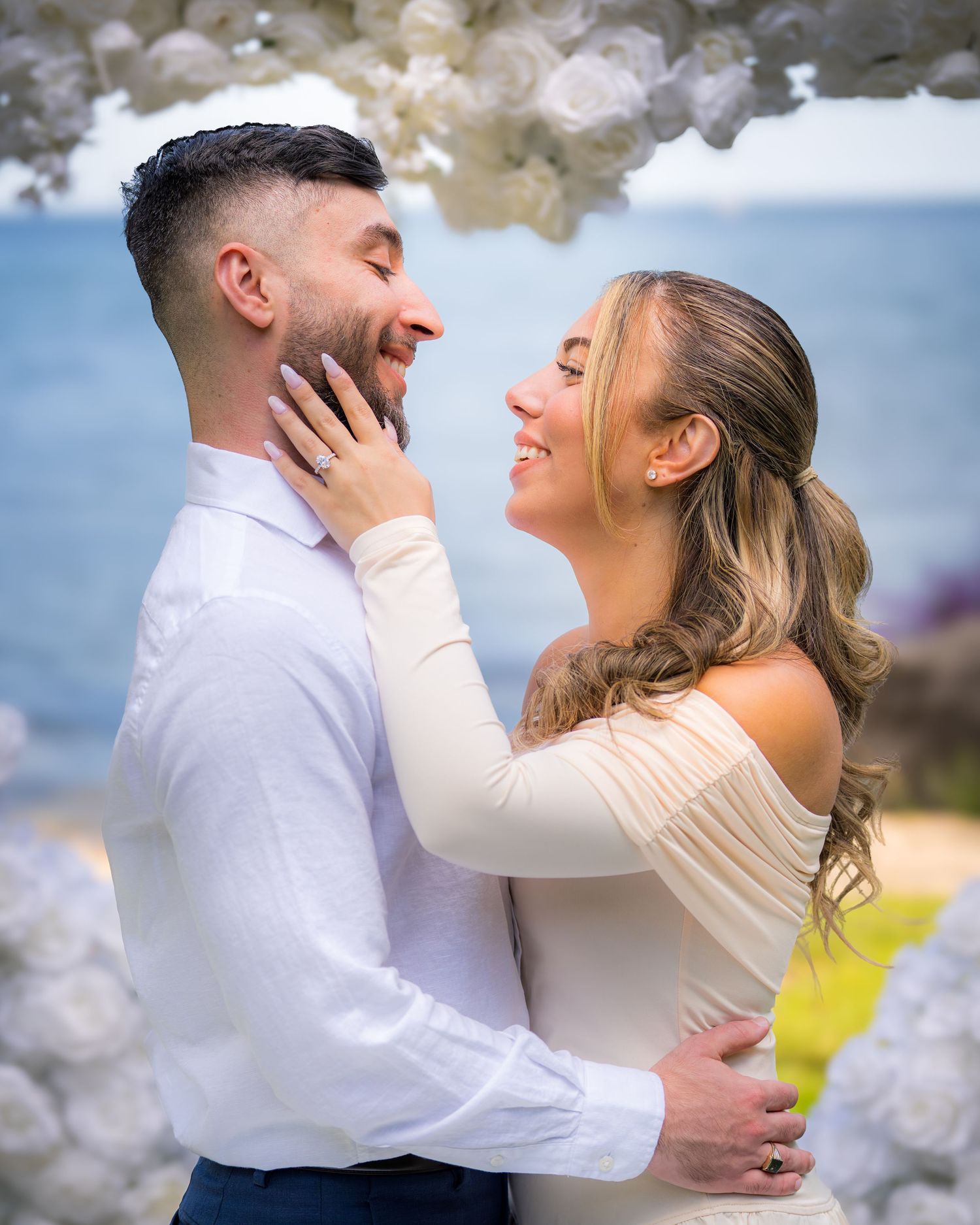 Couple embracing and smiling during an outdoor photoshoot.