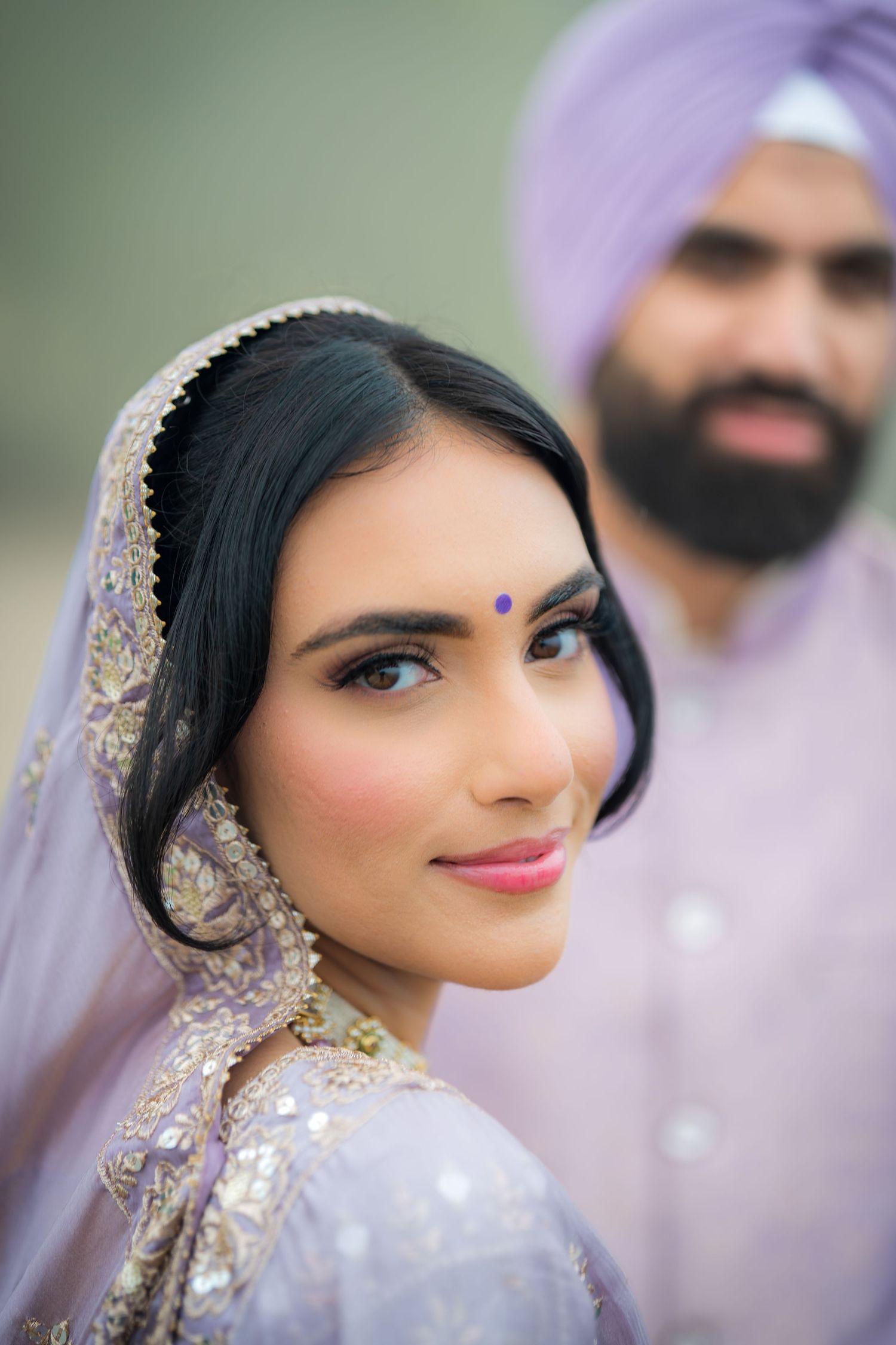Close up portrait showing intricate details of traditional Indian bridal makeup and jewelry.