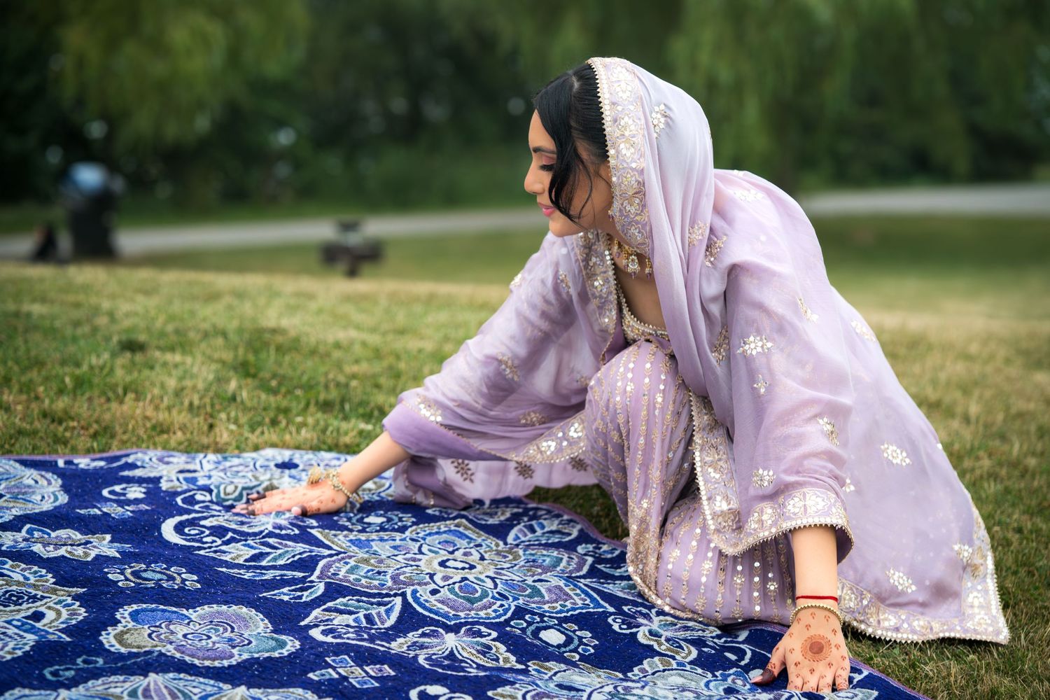 Traditional blue and white patterned blanket laid out on grass in an outdoor setting.