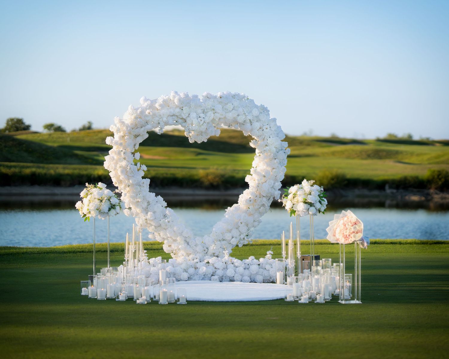 Stunning white floral arches and decor set up for outdoor wedding ceremony.