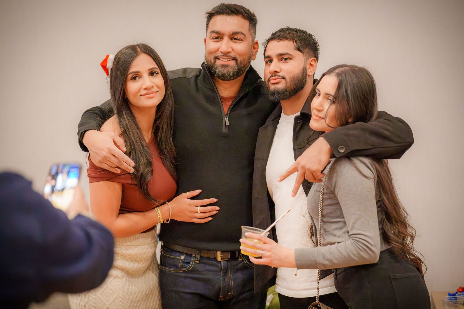 Friends gathering and posing together at an indoor social event.