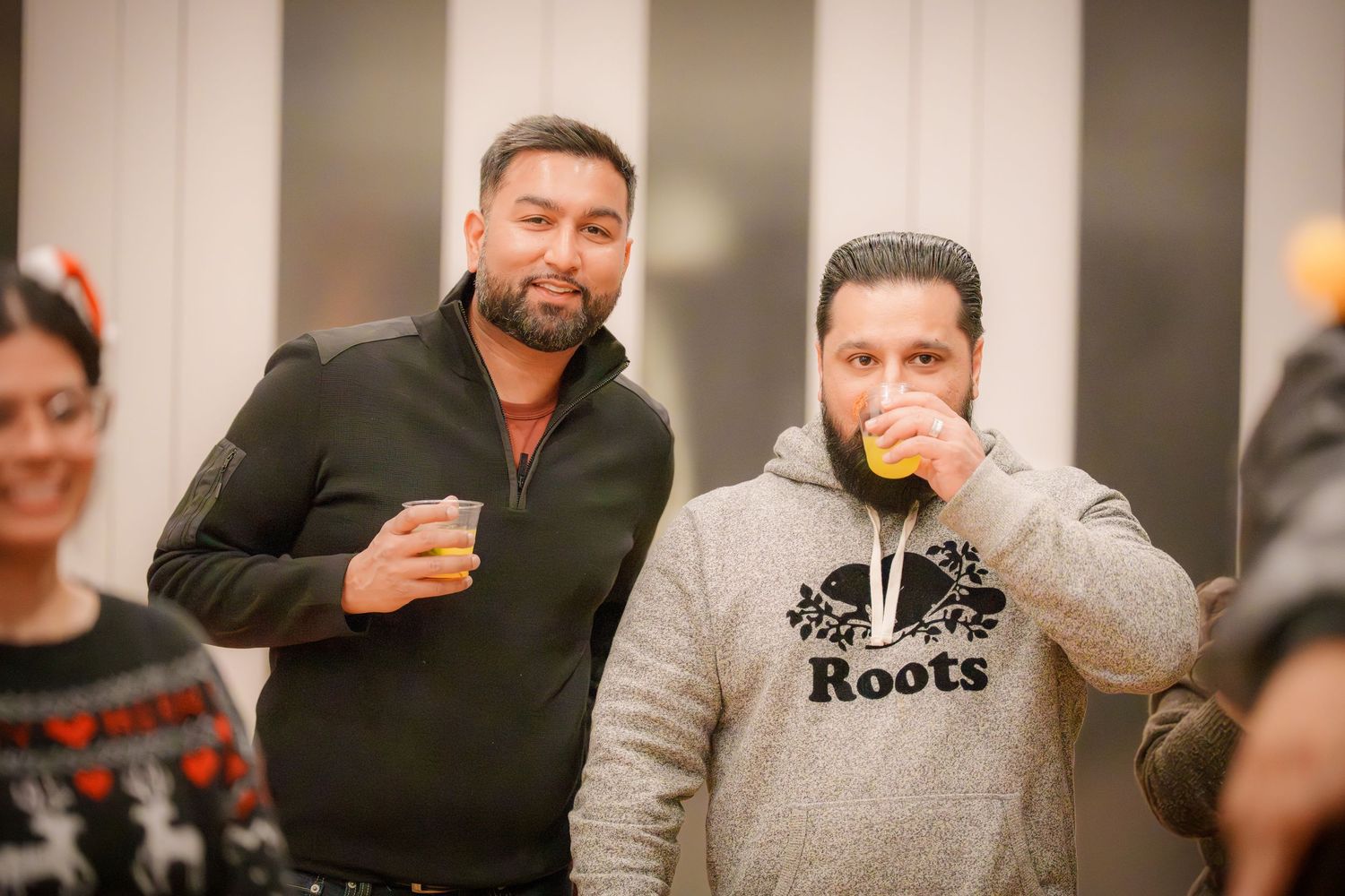 Group of friends socializing at an indoor gathering wearing casual attire.