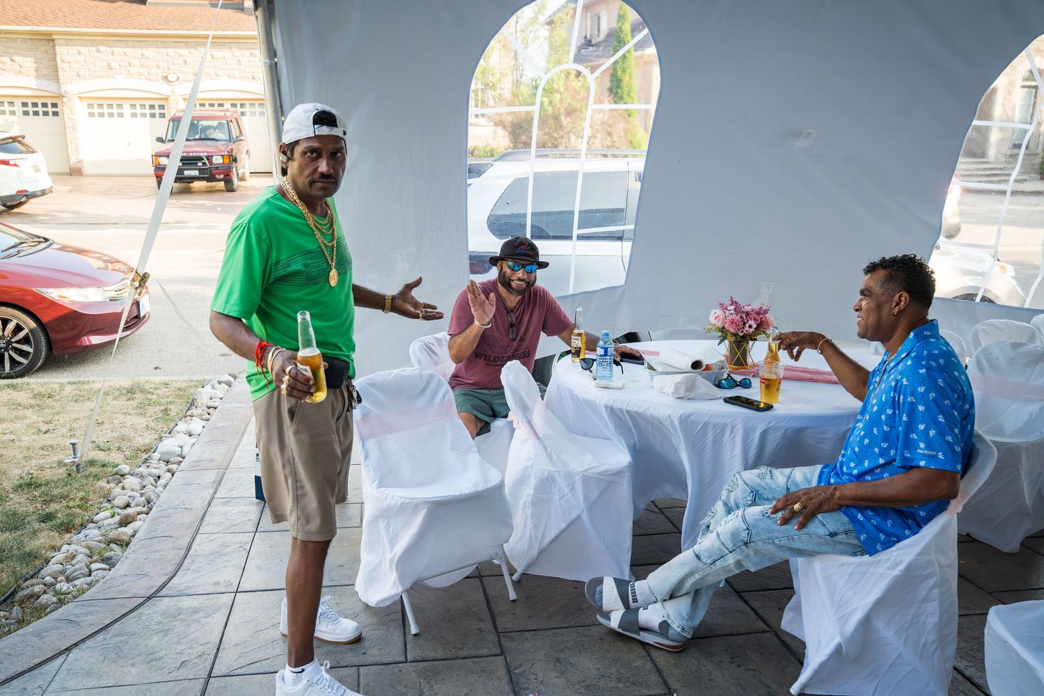 Friends enjoying drinks and conversation at an outdoor covered patio.