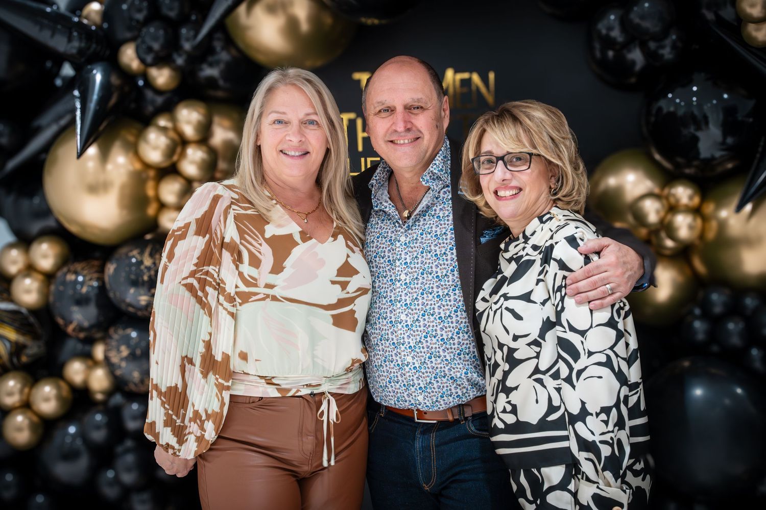 Family group photos at celebration with gold balloon backdrop.