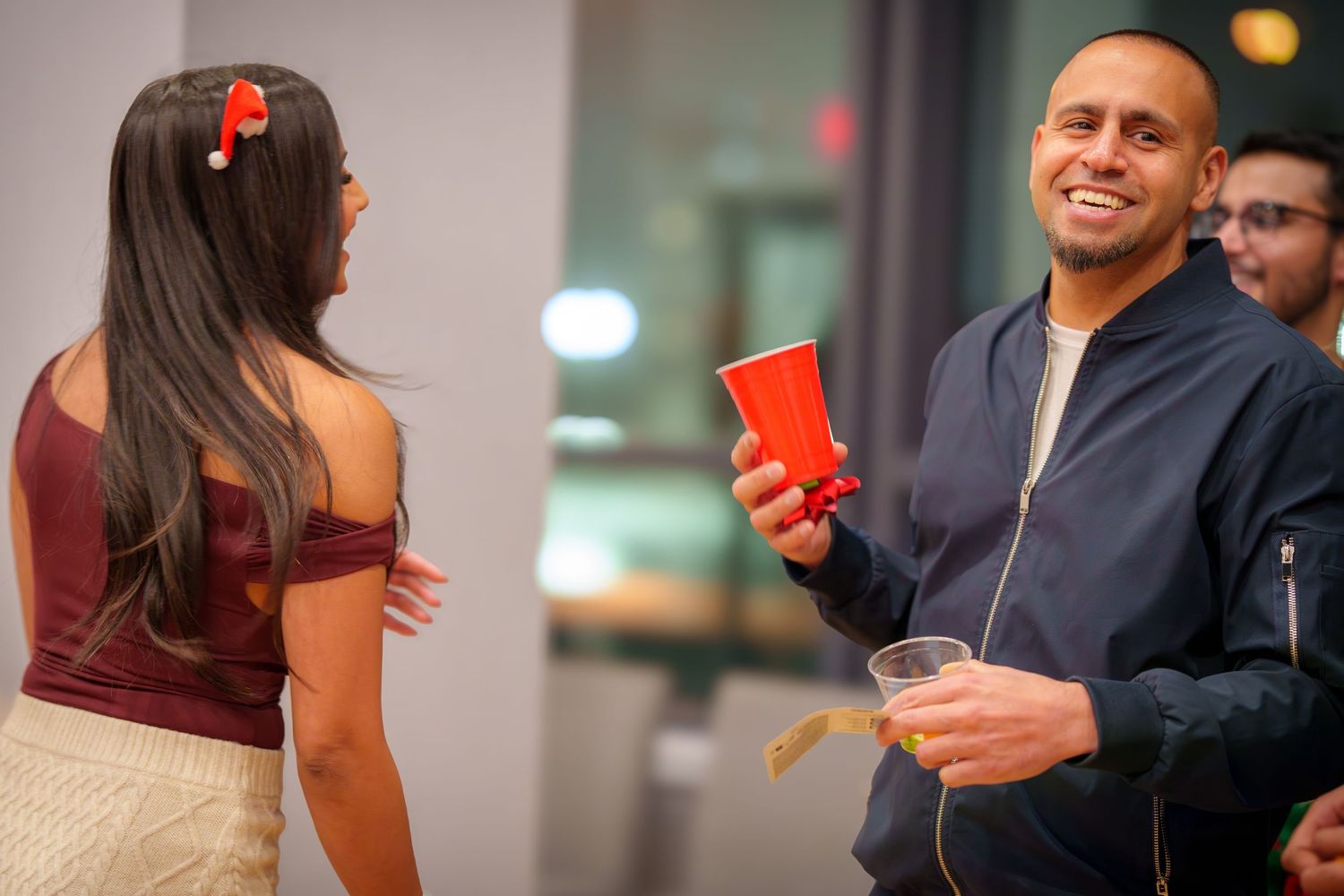 Guests interact during a social event in a modern indoor space with bright lighting.