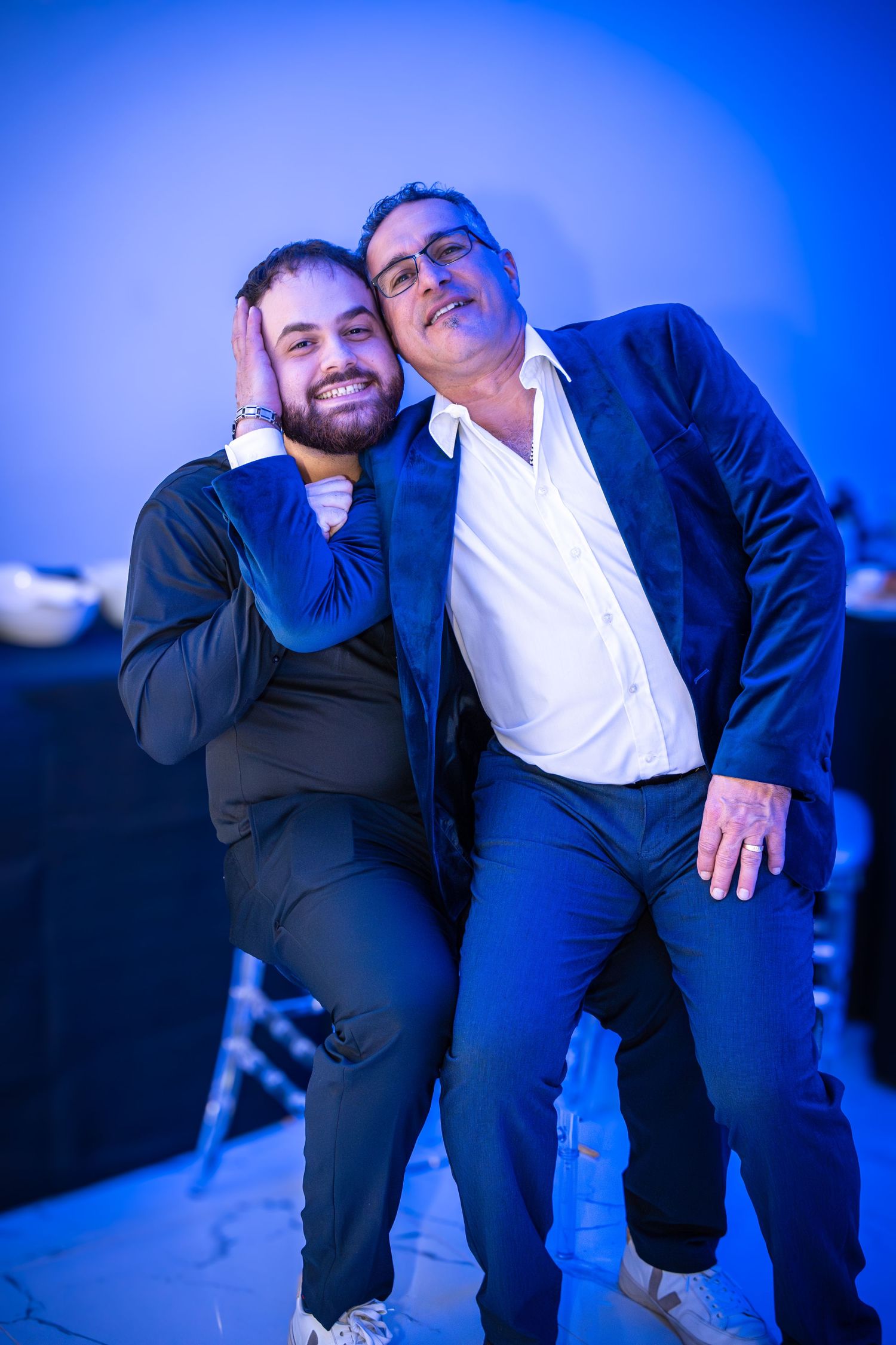 Playful party moments captured under dramatic blue lighting.