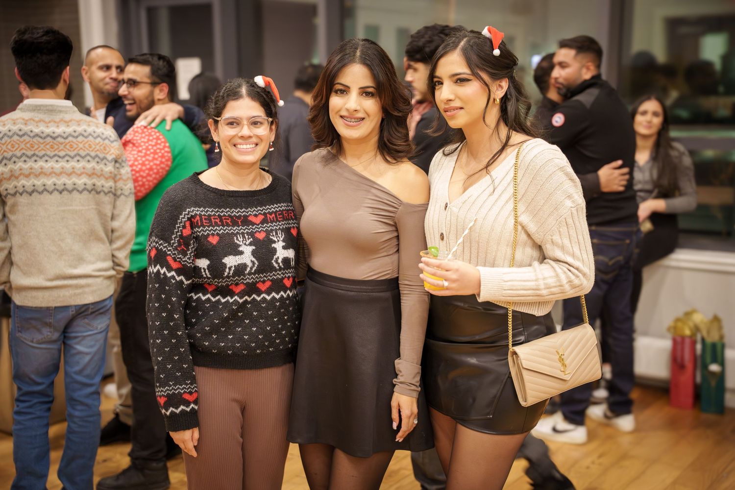 A group of people gathered together at an indoor social event wearing casual attire.