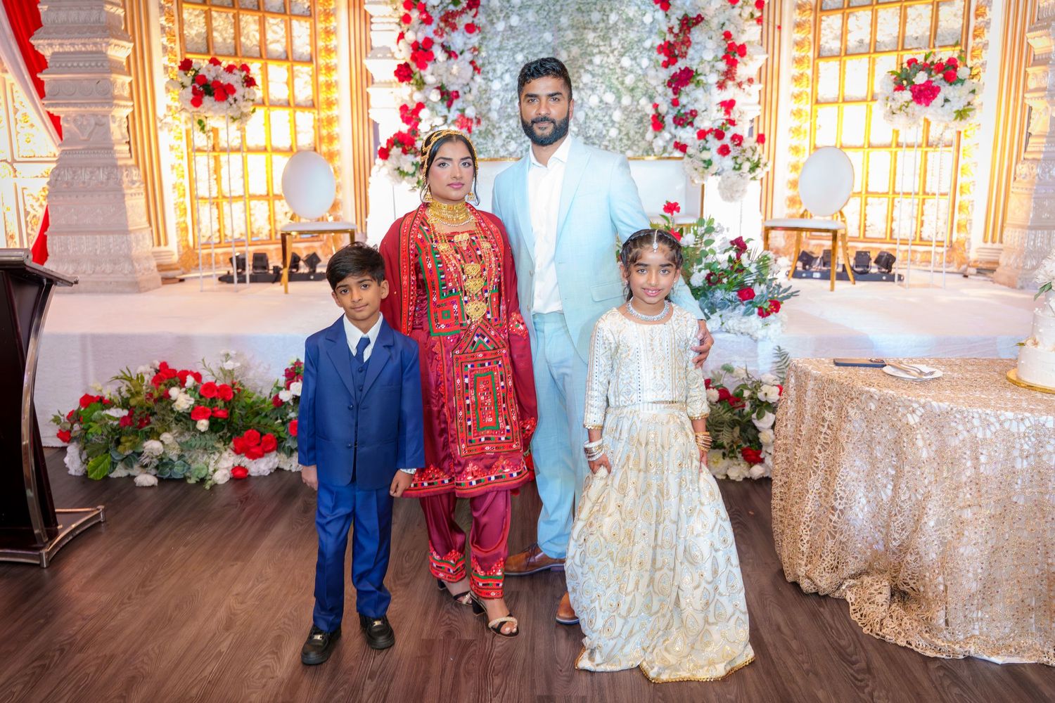 Wedding celebration group photo with family members in traditional and formal attire.