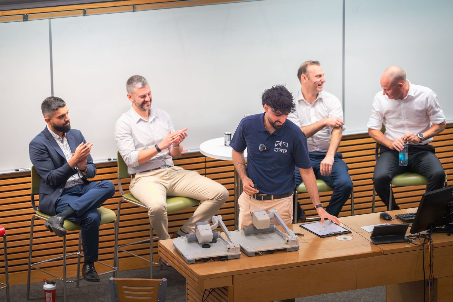 Corporate meeting space features curved bench seating and engaged participants during presentation.