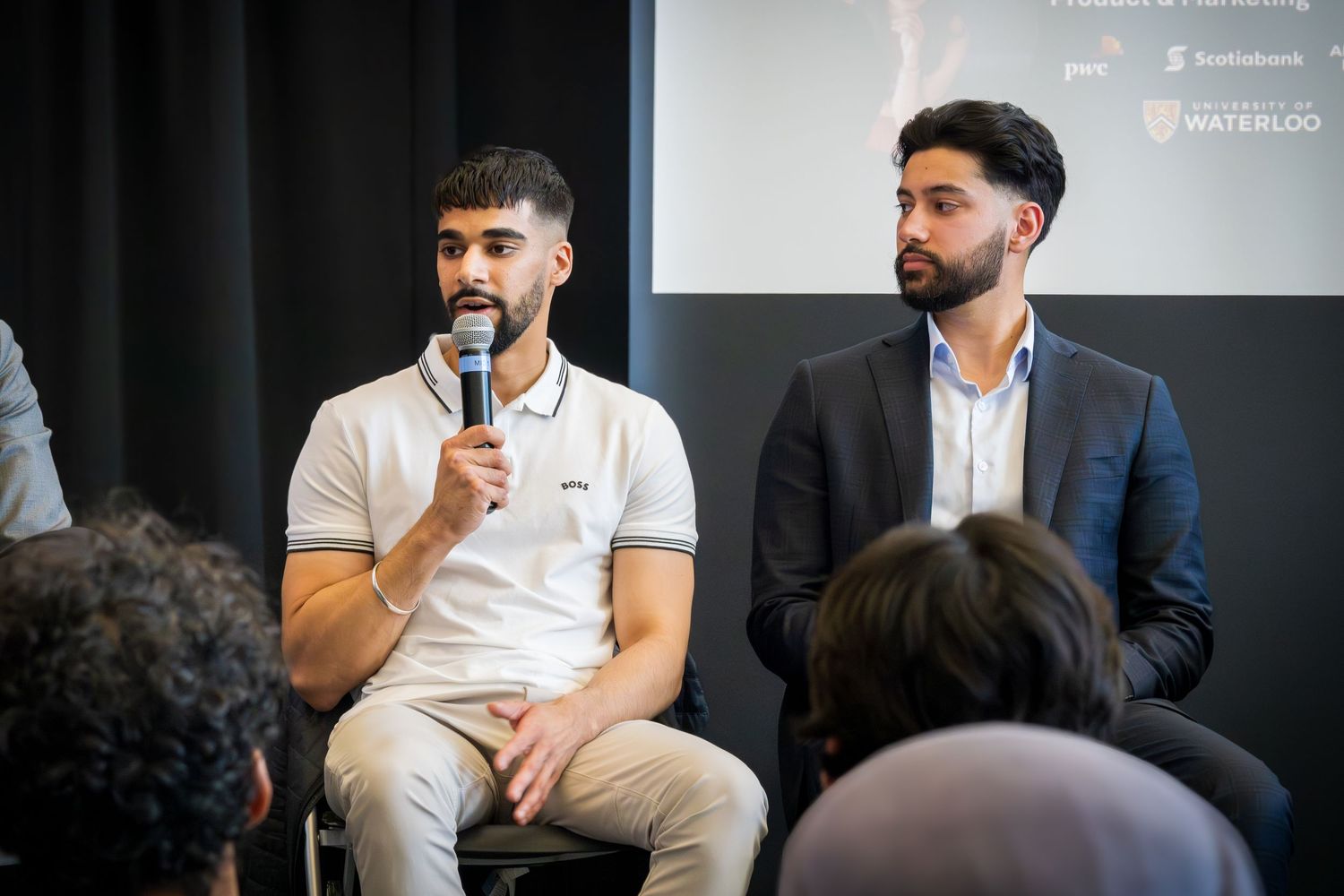 Business professionals share insights during staged panel conversation.