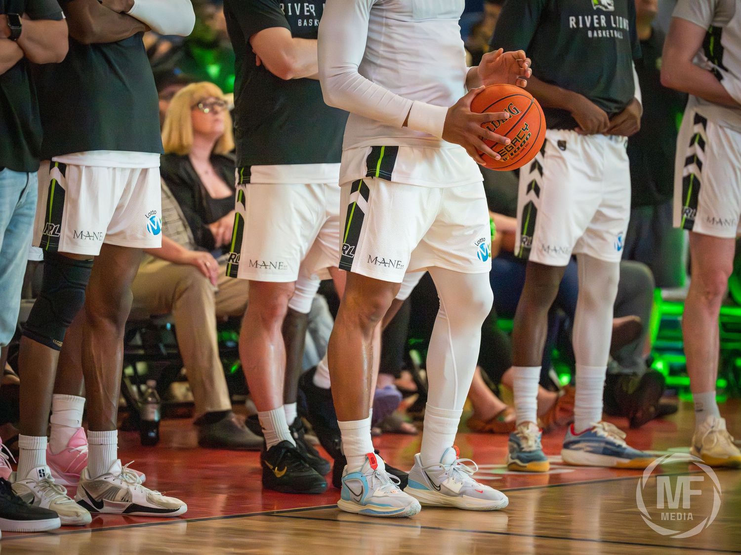 Niagara River Lions basketball players standing on the sideline during a CEBL game.