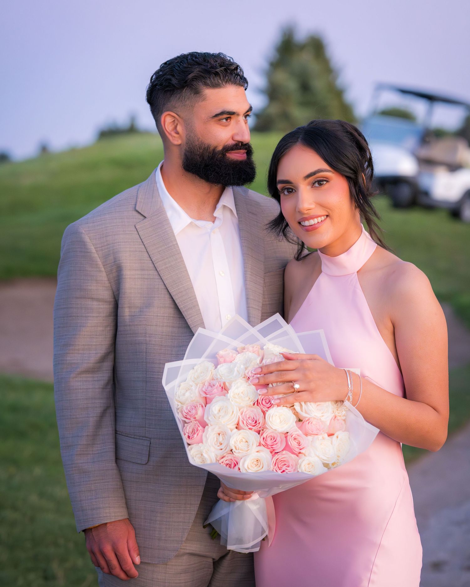 A couple shares tender moments during their outdoor photoshoot with a rose bouquet.