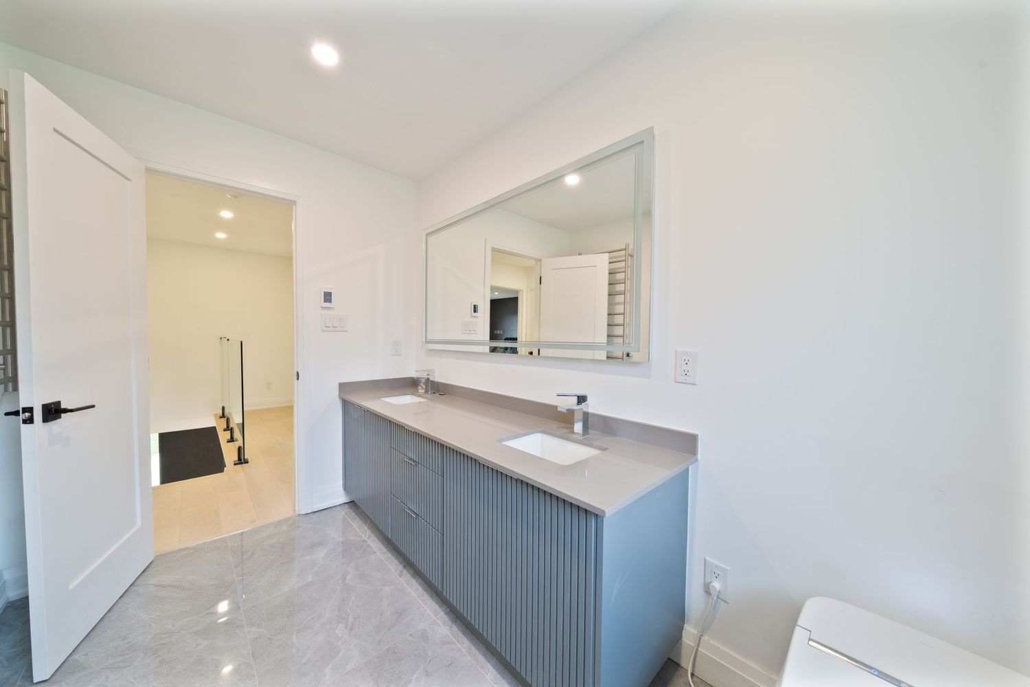 Clean white interior hallway with grey accent wall and recessed lighting showing modern architectural details.