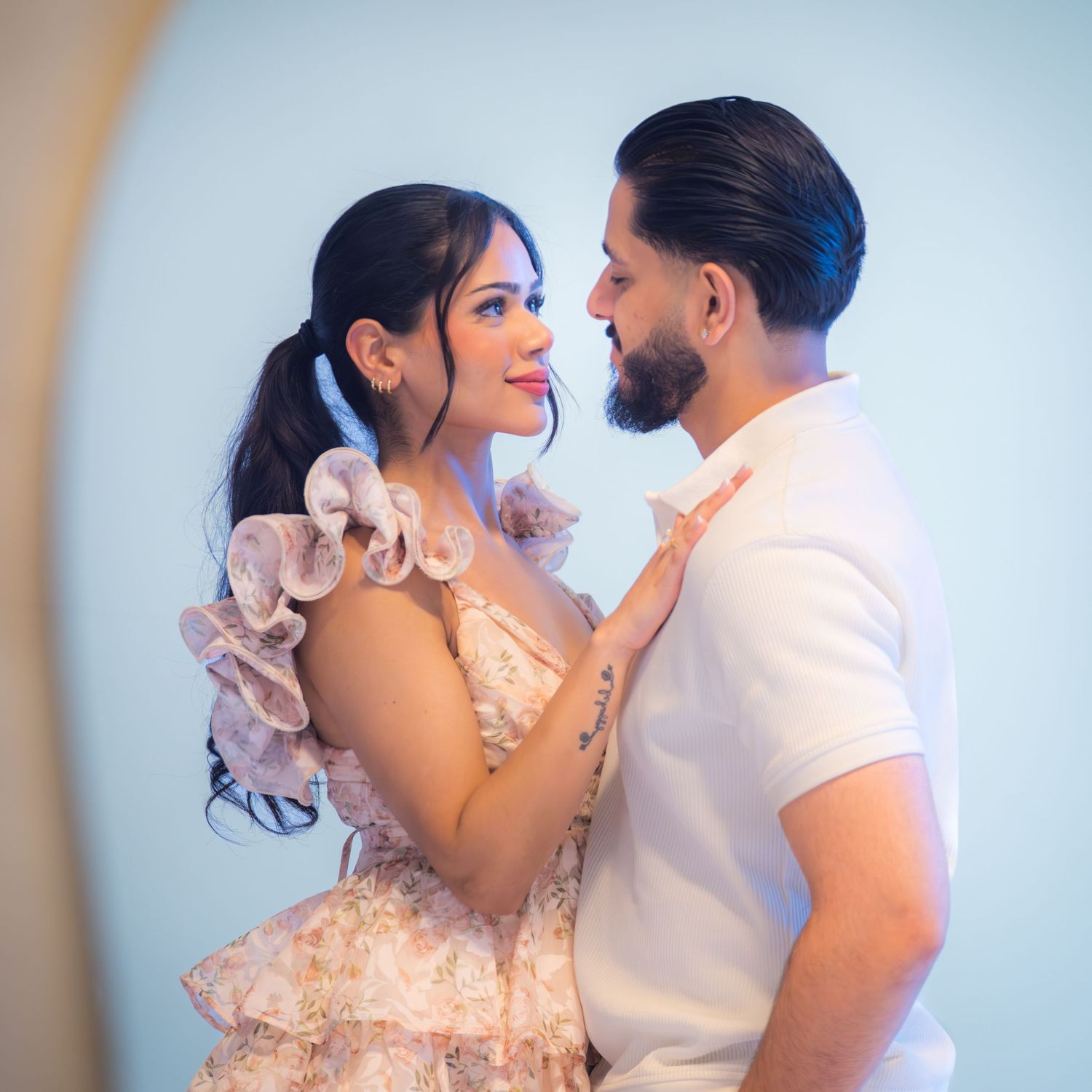 Couple gazes into each other's eyes during romantic engagement shoot in soft blue light.