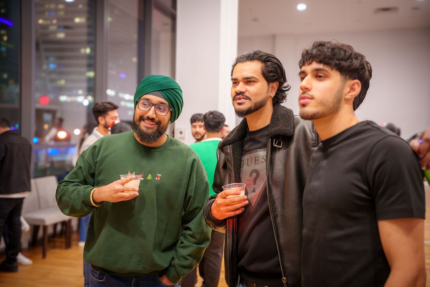Group of friends gathered in casual attire at an indoor social event.