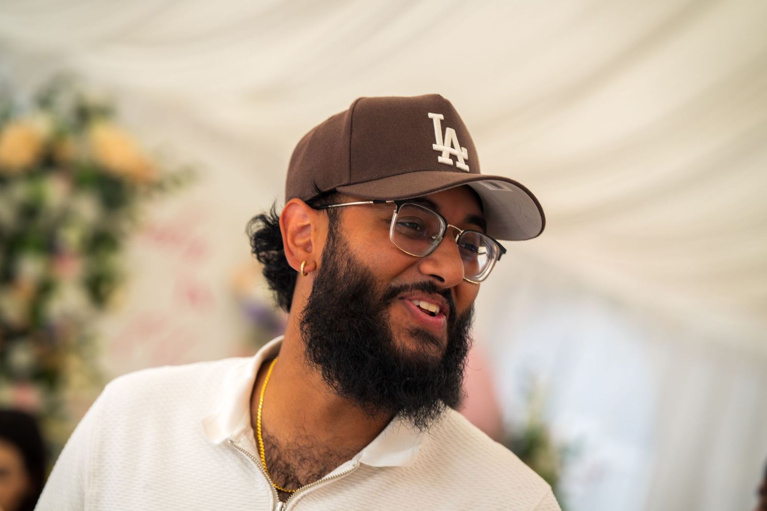 Male guests wearing baseball caps smile during the baby shower celebration.