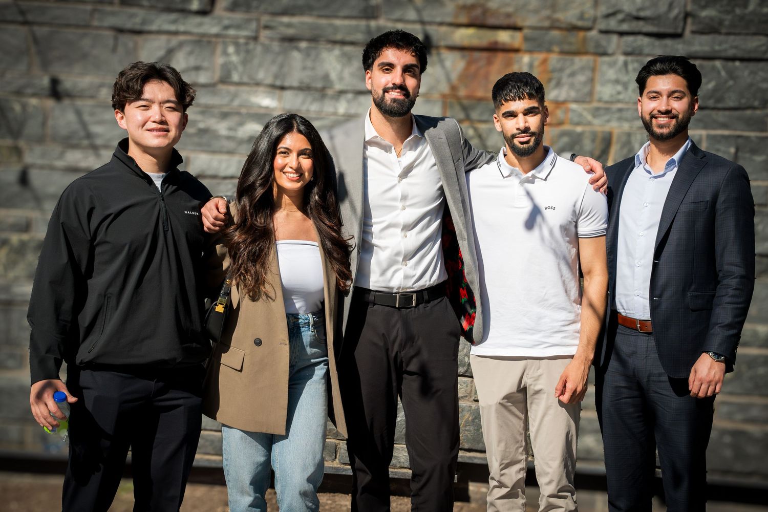Casual group photo of speakers against brick wall background.