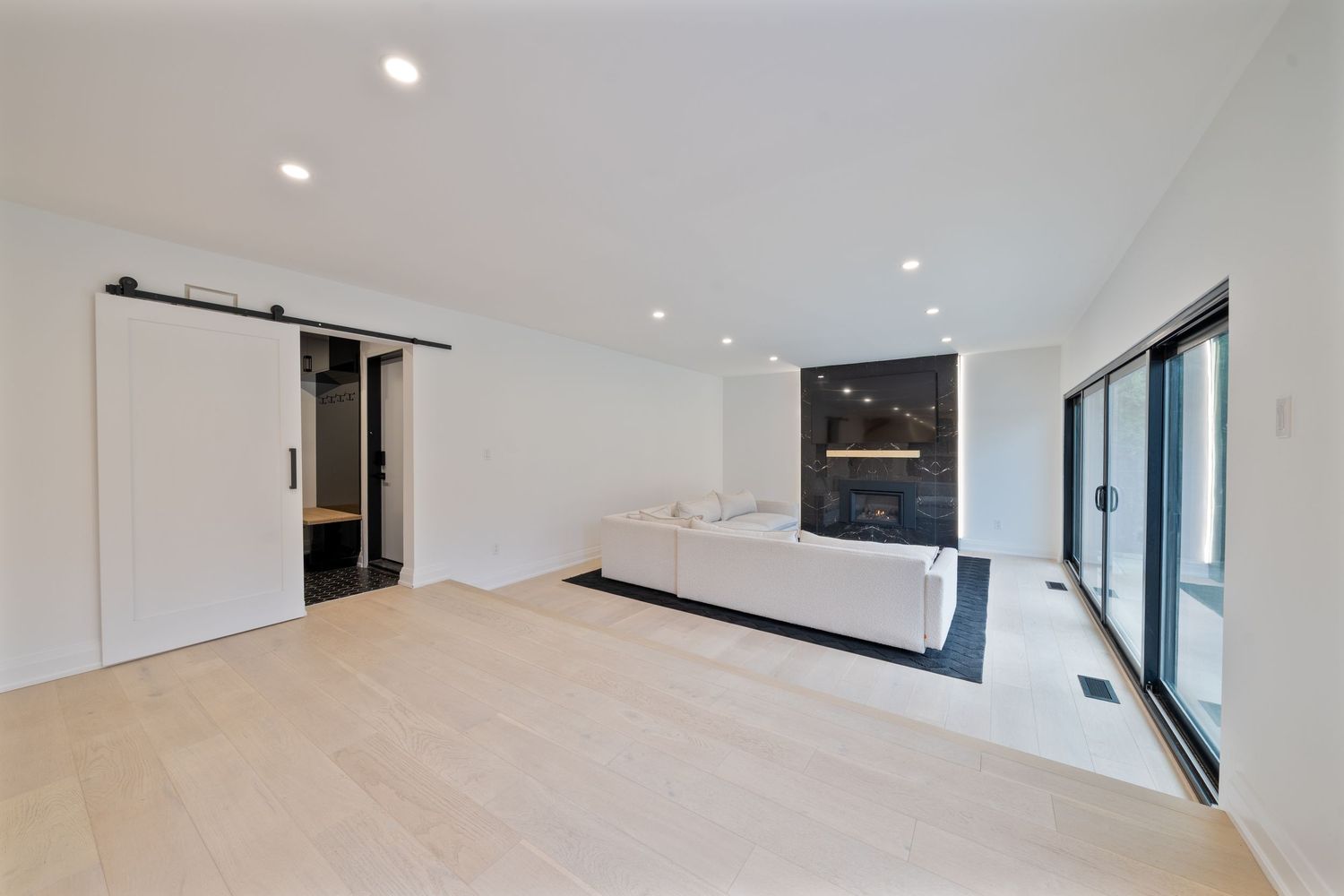 Modern white kitchen with recessed lighting, sleek cabinets, and stainless steel appliances features clean minimalist design.
