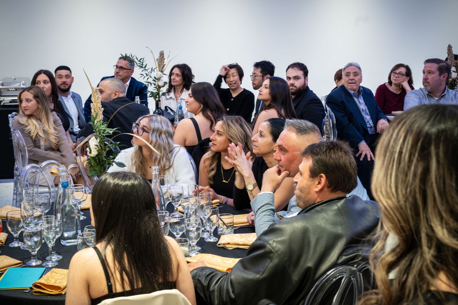 Business professionals seated at tables during a corporate dinner event.
