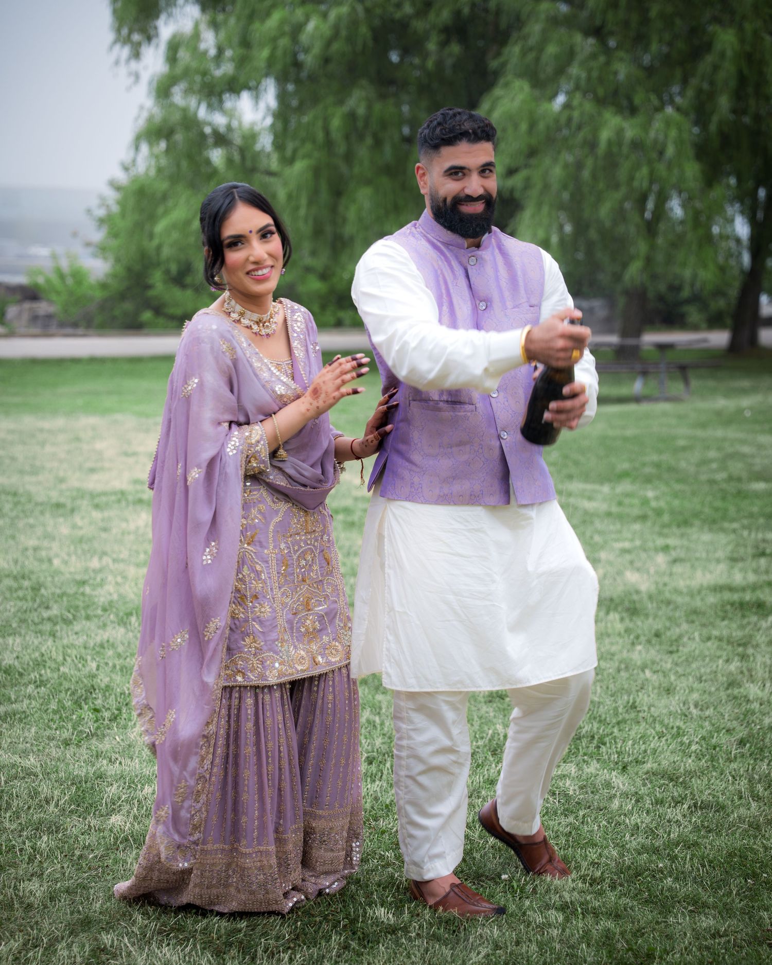Couple in traditional Indian attire playfully interacting in a park setting.