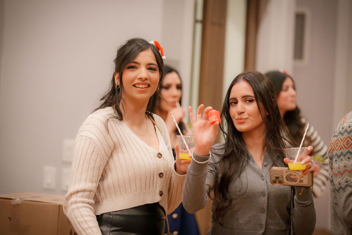 Friends enjoying drinks and conversation at an indoor gathering.