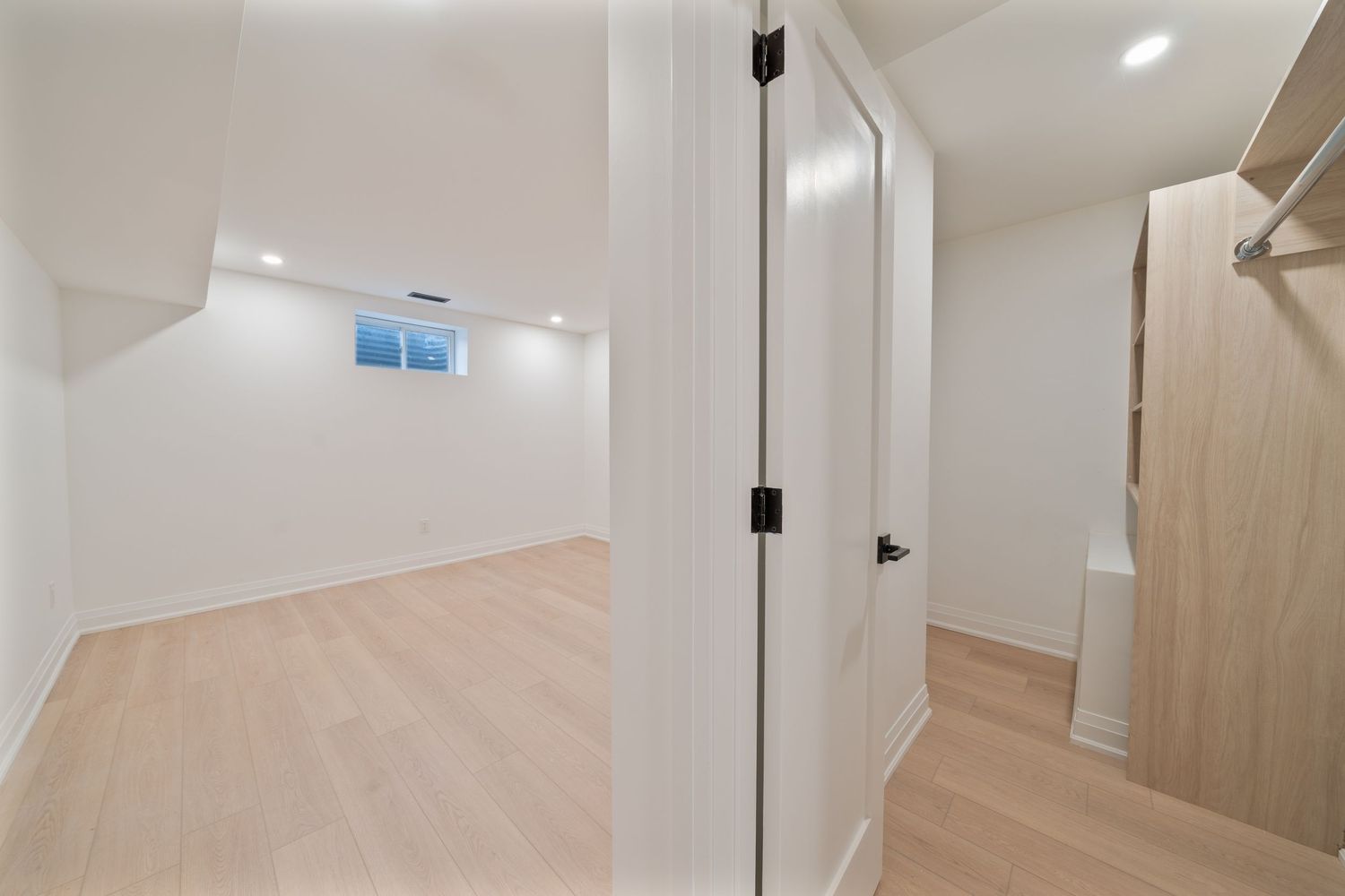 Modern white bathroom interior with glass shower enclosure, floating vanity, and light wood accents.