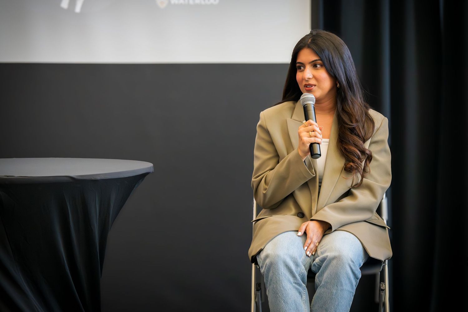 Professional panel discussion featuring speakers in business attire on stage.
