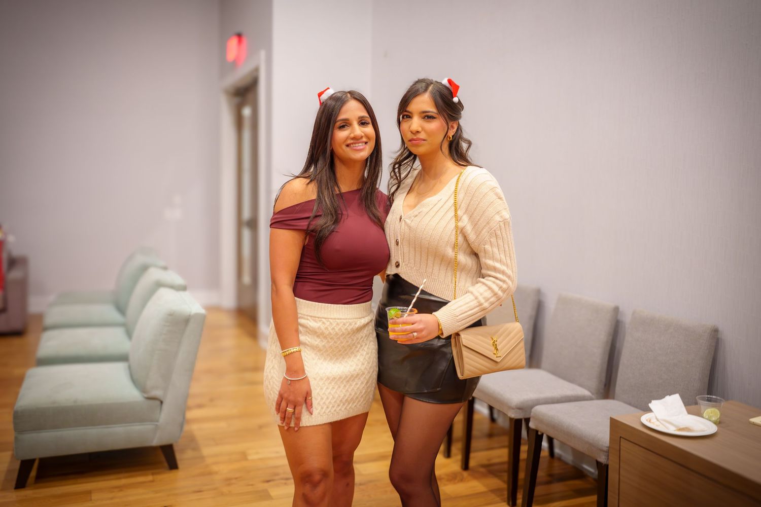 People enjoying a casual indoor gathering in a modern living room with gray furniture.