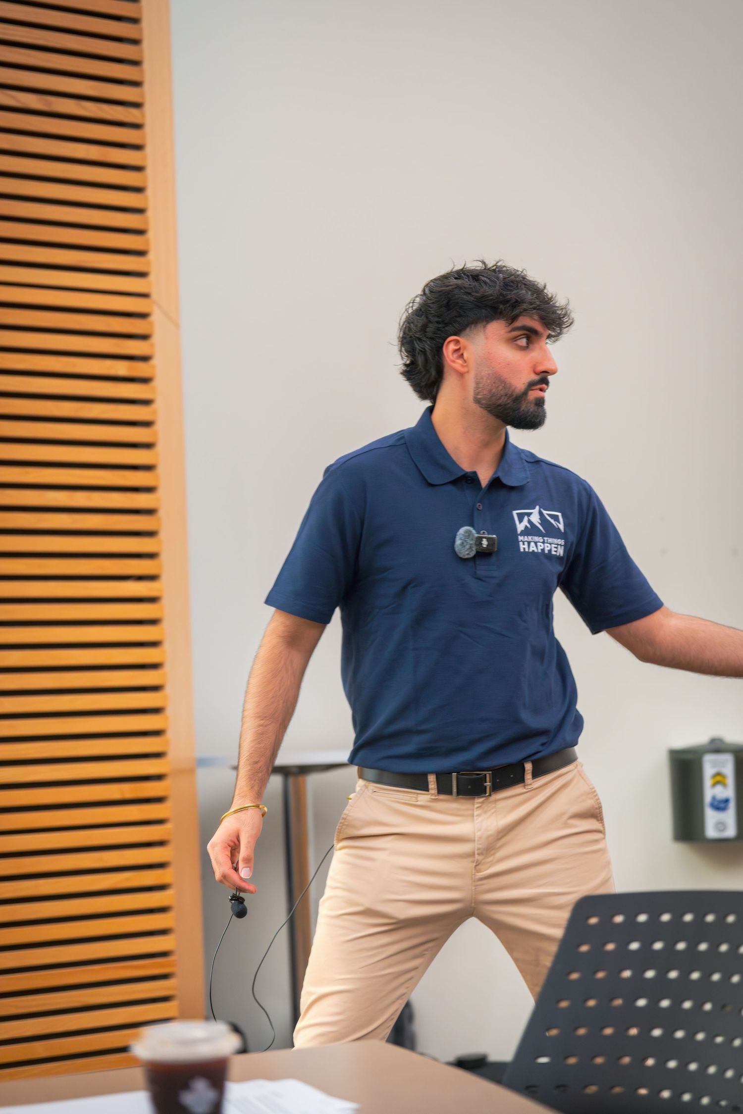 Speaker in navy uniform demonstrating animated gestures during presentation.