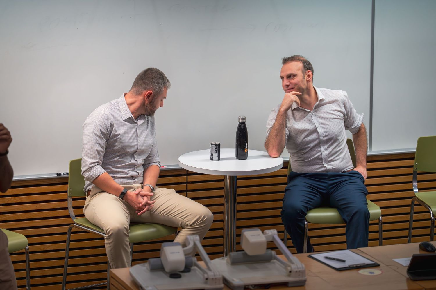 People seated in a casual meeting setup with modern office furniture.